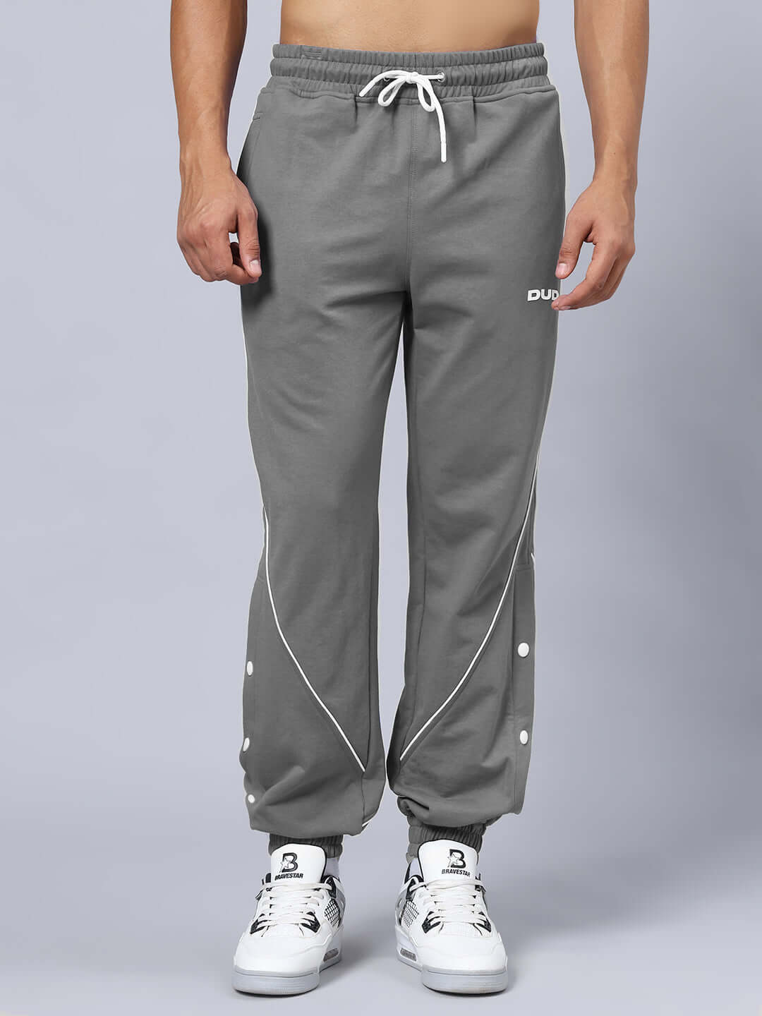 Grey BROSSFINE CONSTRAST joggers with white detailing, modeled by DUDS, offering custom fit and made-to-order options.