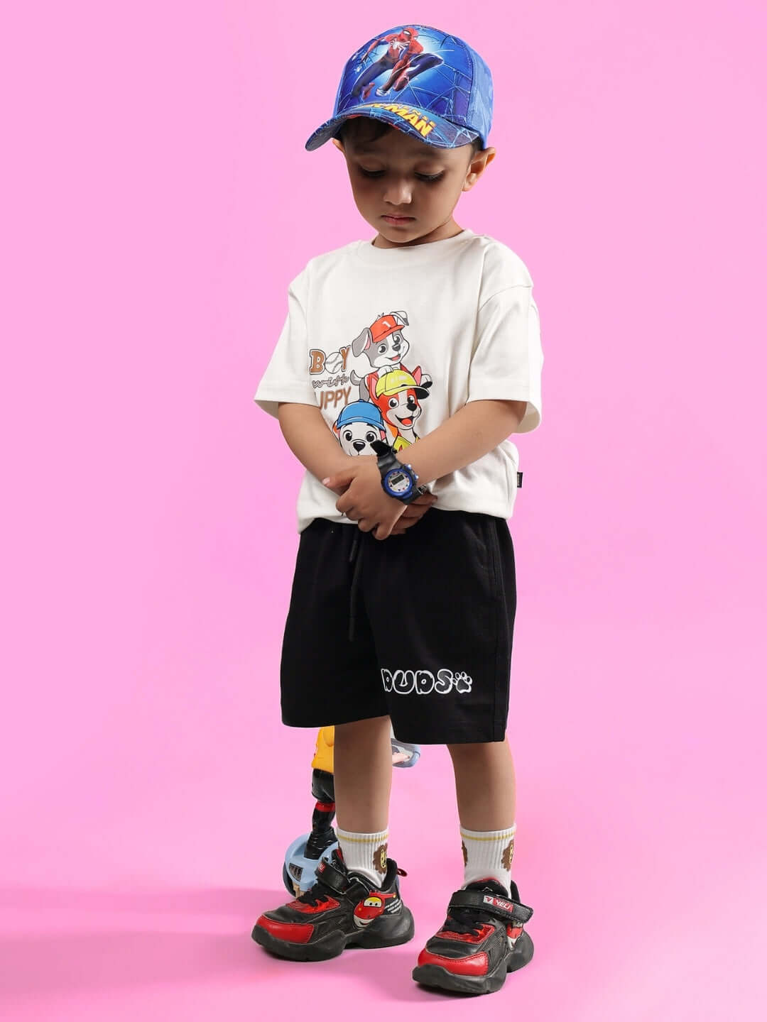 Child wearing BRUNO CO-ORD FOR BOYS & GIRLS OFF WHITE-BLACK with colorful cap and sneakers.