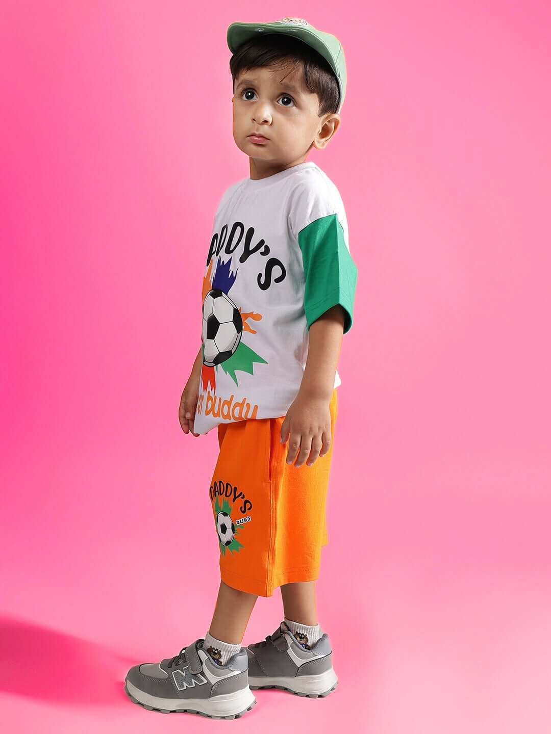 Child wearing BUDDY CO-ORD FOR BOYS & GIRLS WHITE-ORANGE set against pink background