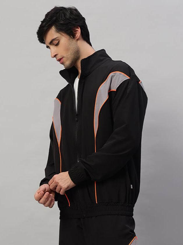 Model wearing black Bullet Parachute Jacket with orange accents, showcasing custom fit option by DUDS.