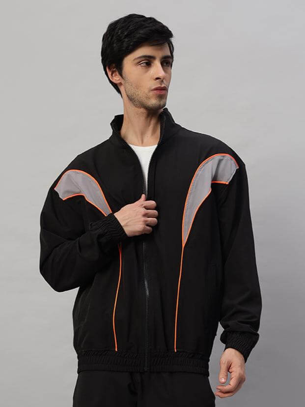 Man wearing black Bullet Parachute Jacket with orange accents, designed by DUDS, available for custom fit. Made to order.