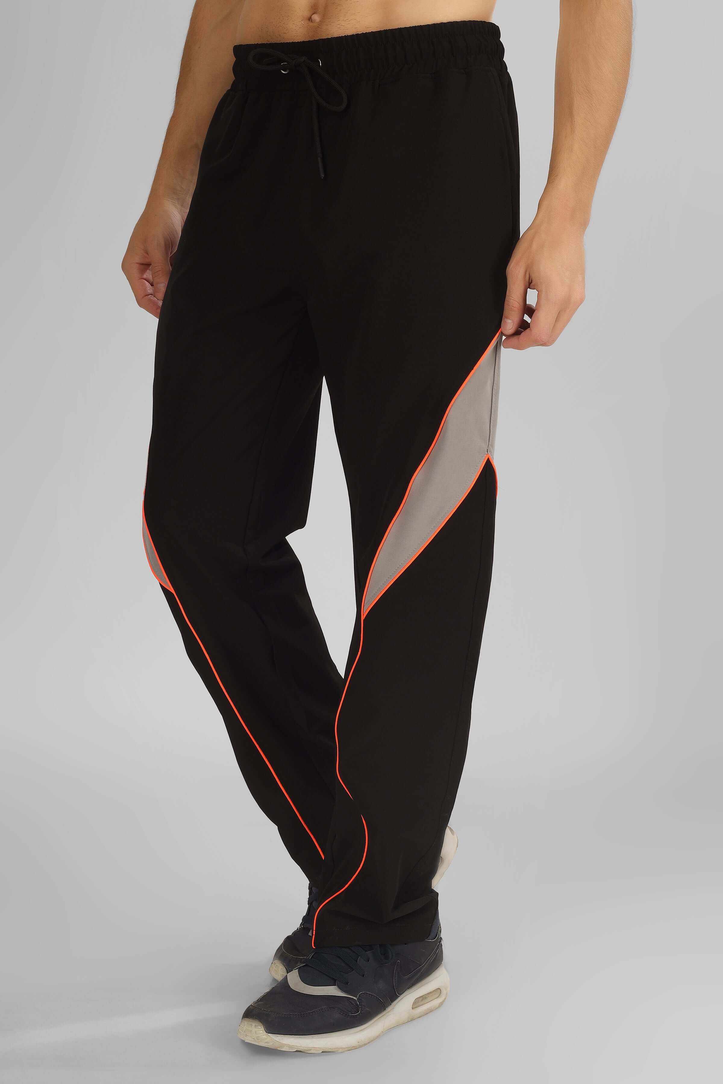 Man wearing black BULLET RELAXED FIT CARGO PANTS with orange trim, customizable for a tailored fit, ideal for comfort and style.