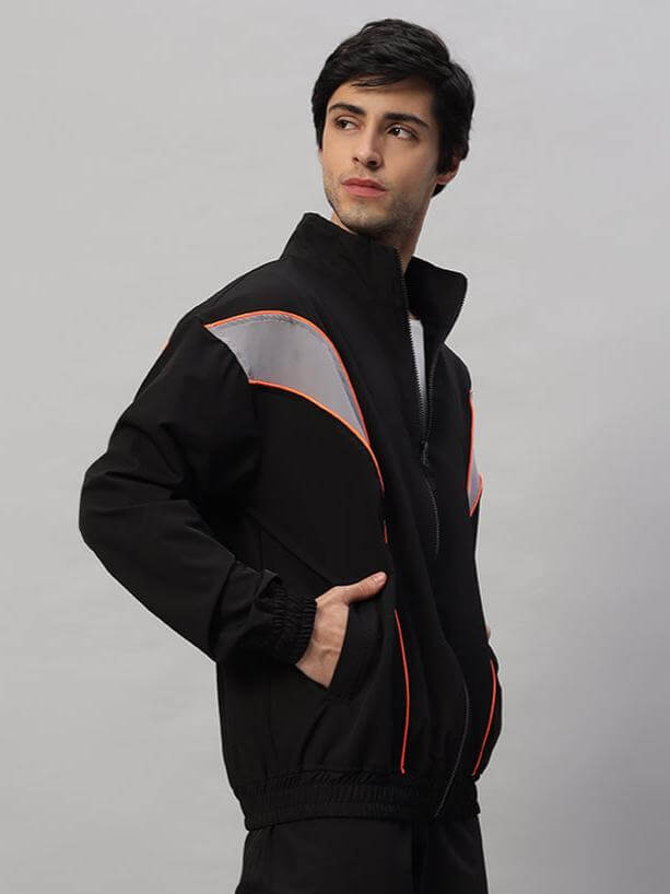 Model wearing black Bullet Parachute Jacket by DUDS, featuring reflective panels and custom fit options for personalized style.