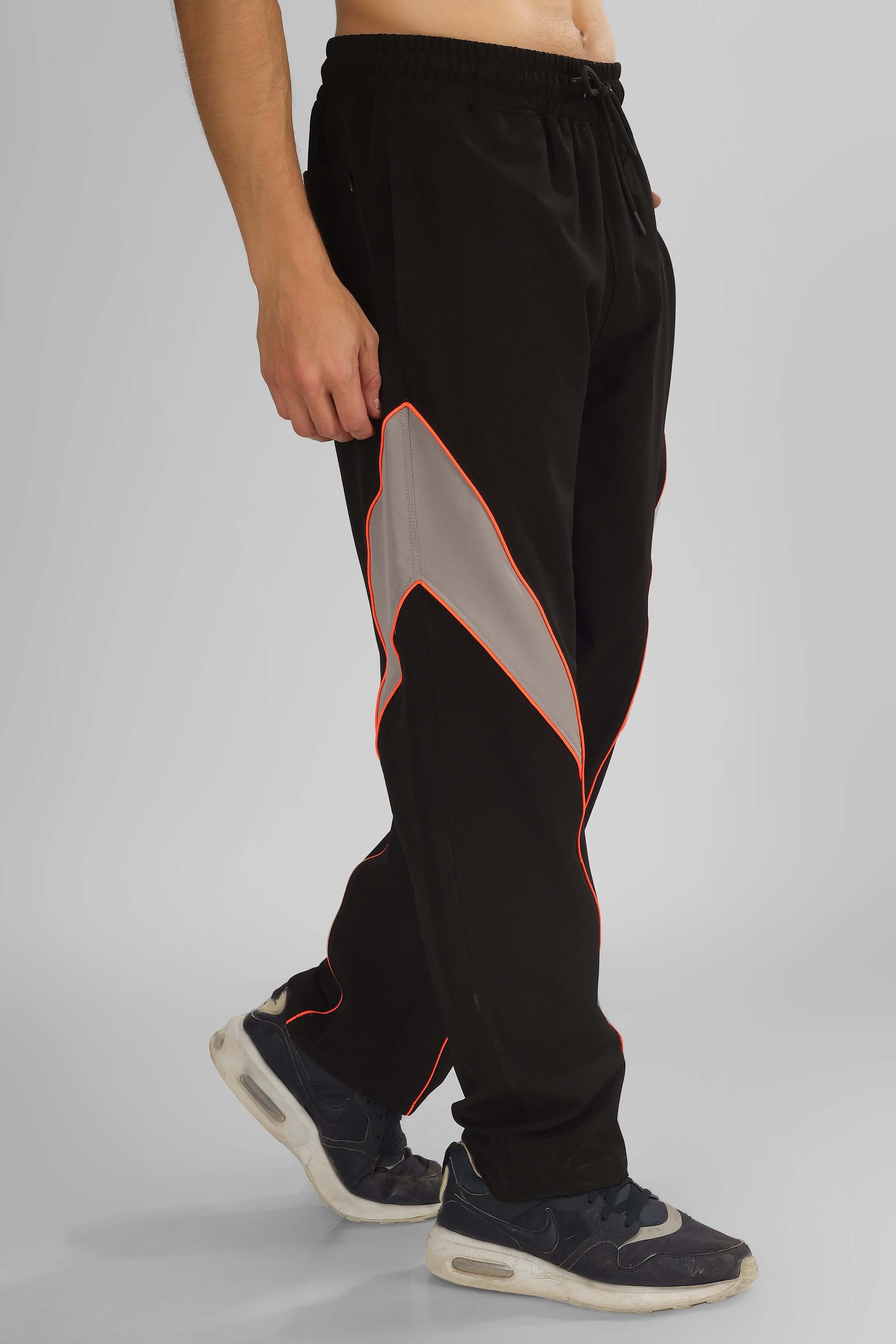 Person wearing black Bullet Relaxed Fit Cargo Pants with orange and grey accents.