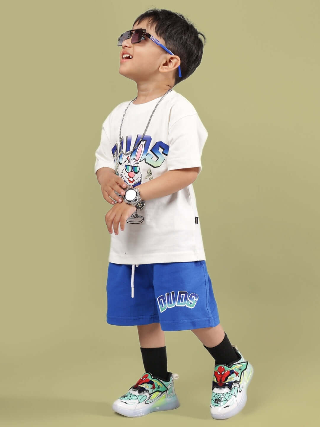 Child wearing a stylish BUMBLE co-ord outfit in off white and royal blue, featuring a graphic t-shirt and matching shorts by DUDS.