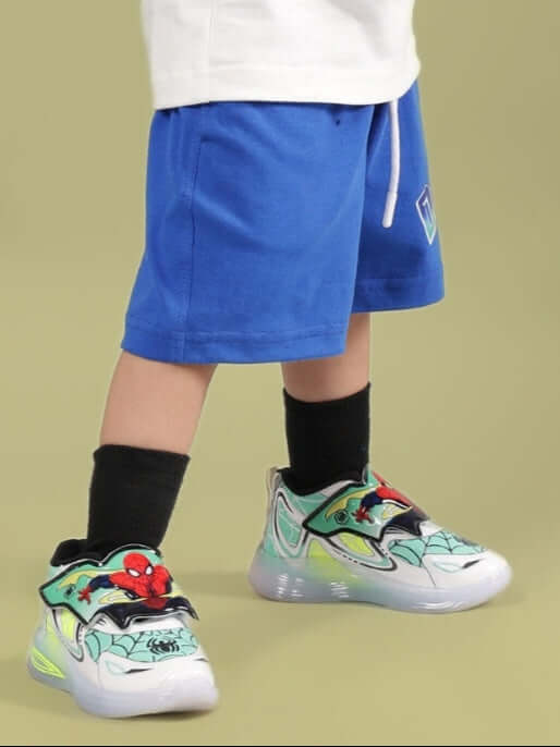 BUMBLE SHORTS FOR BOYS & GIRLS ROYAL BLUE displayed in a unique style with colorful sneakers.