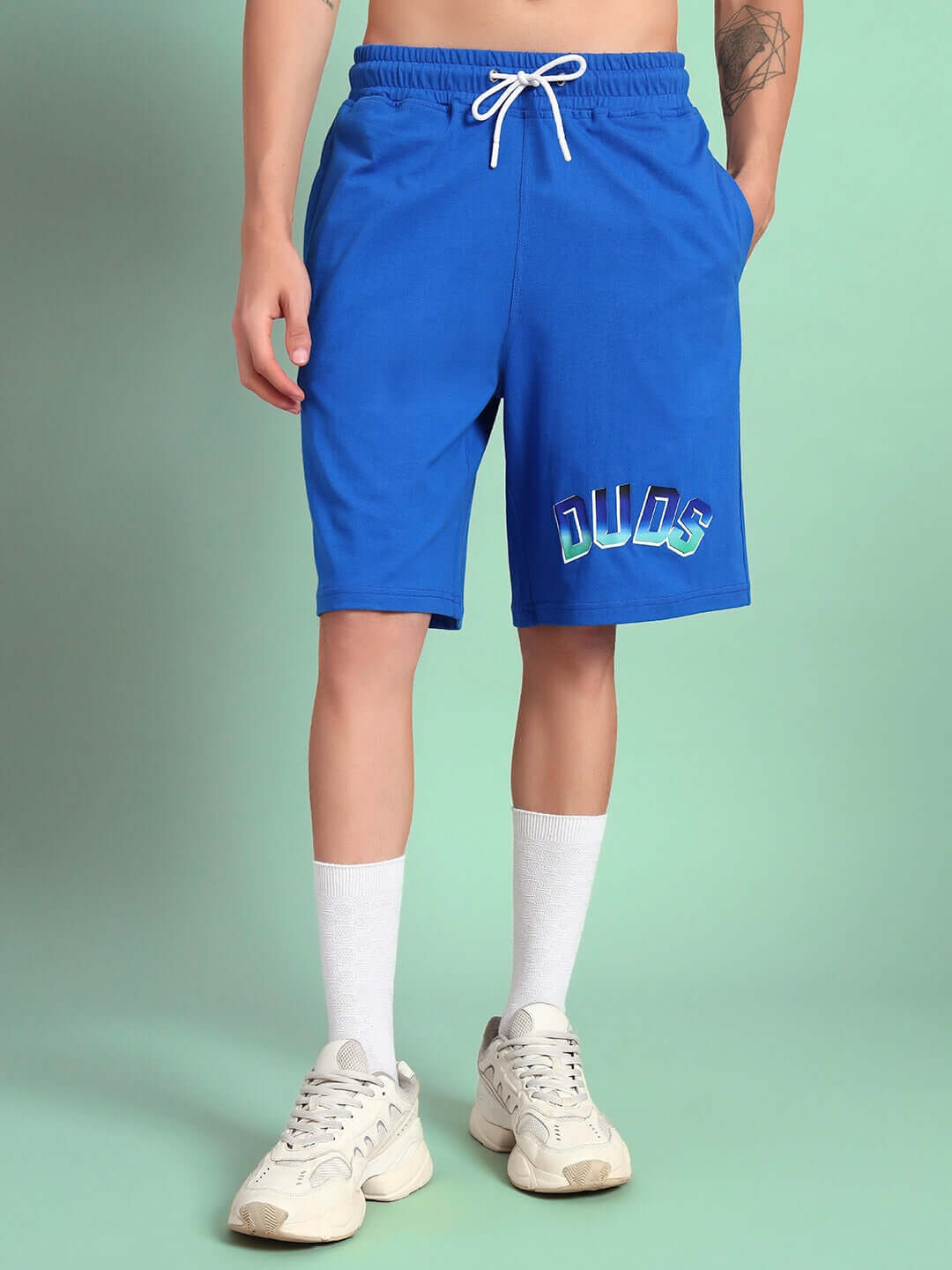 Man wearing blue Bunny Bugs Summer Shorts with DUDS logo, showcasing casual summer style.