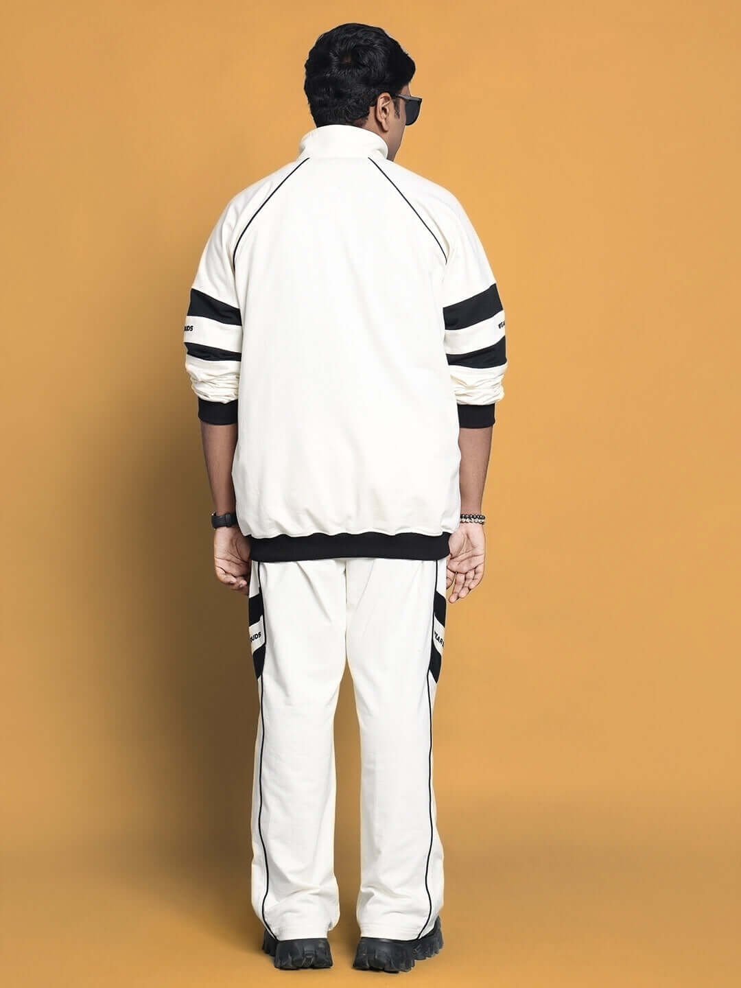 Rear view of man wearing CALEDONIA CO-ORD SET OFF WHITE in soft cotton terry, showcasing minimalistic streetwear style.