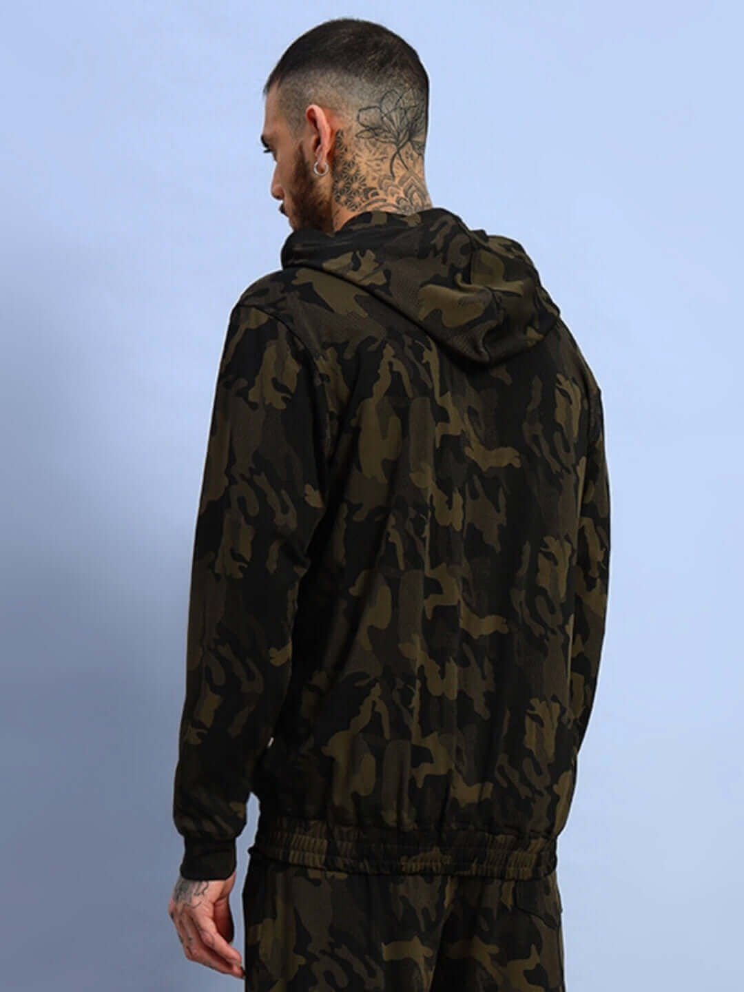 Back view of a man wearing a camo green trench camouflage jacket from DUDS, featuring a hood and unique pattern design.