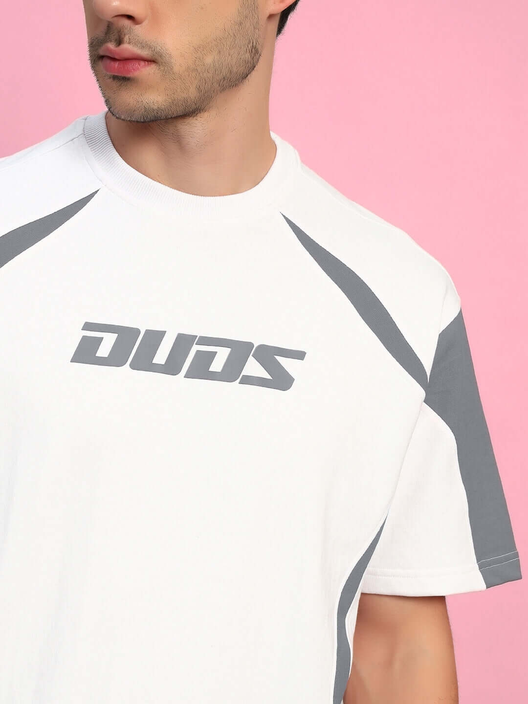 Model wearing Candor oversized white grey t-shirt, premium cotton blend, on a pink background.