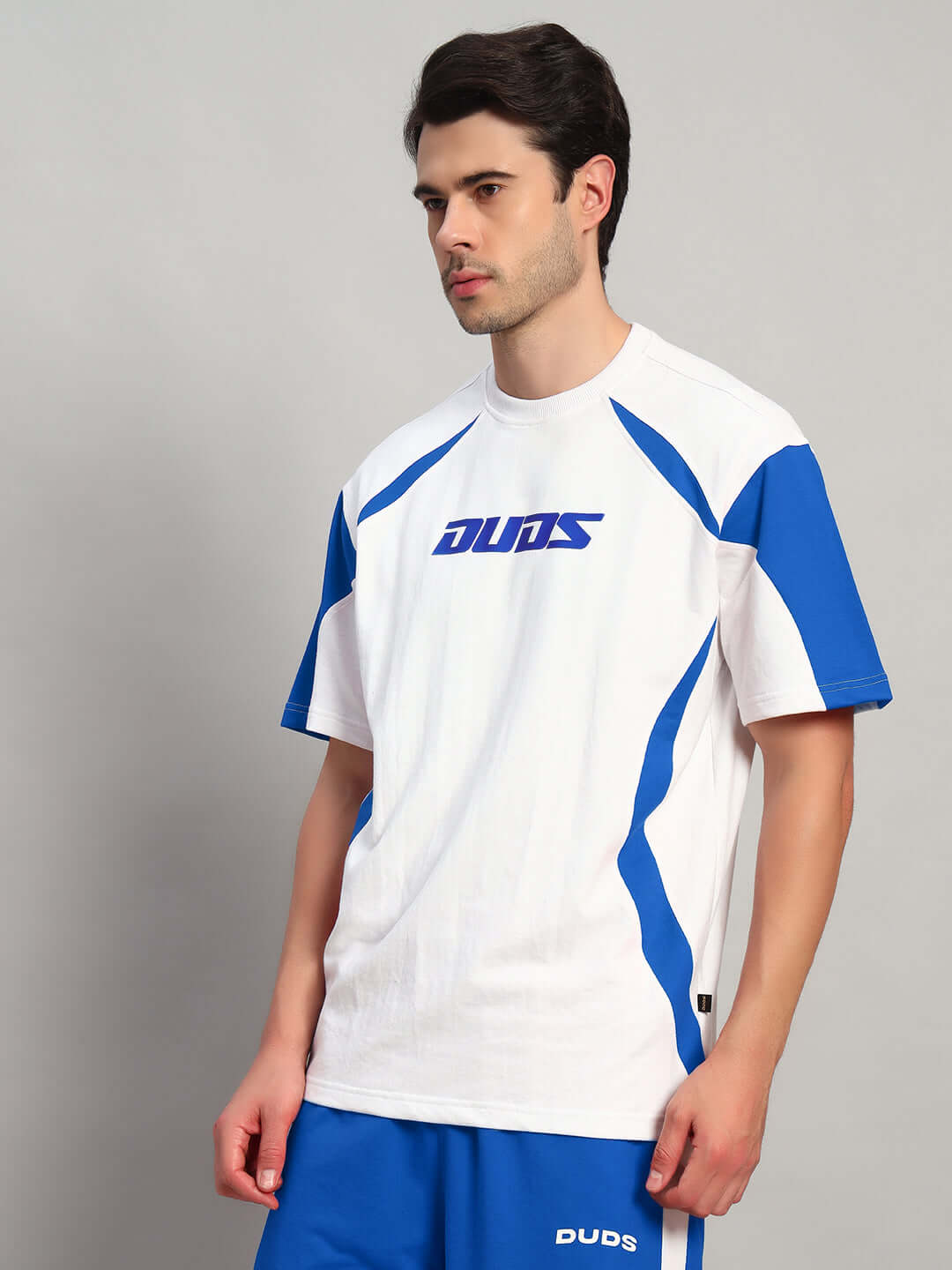 Model wearing Candor oversized white-blue T-shirt made from premium heavy gauge fabric, featuring blue accents and logo design.