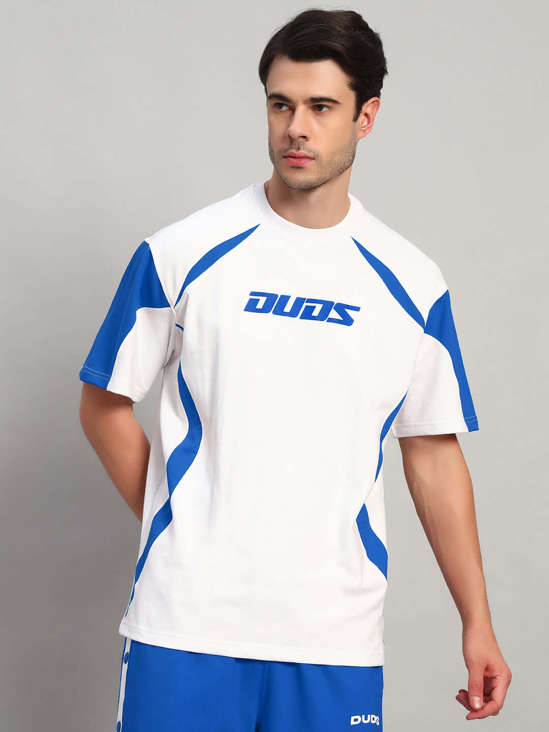 Model wearing a Candor over-sized T-shirt in white and blue, made from premium heavy gauge fabric with French terry cotton blend.