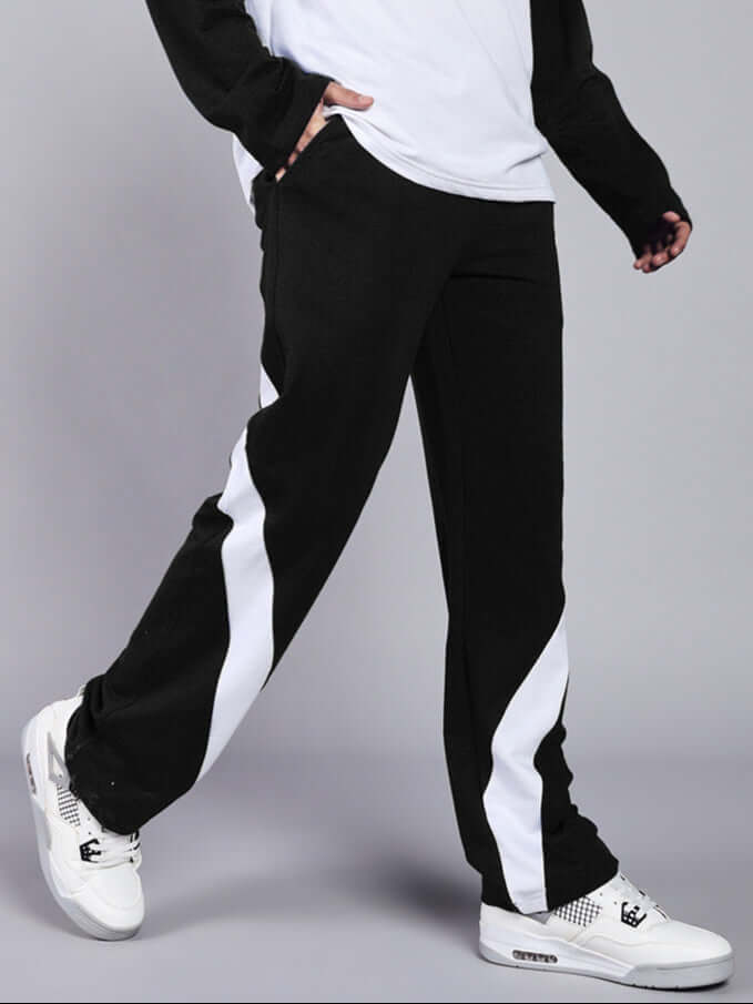 Person wearing Celestine cool relaxed fit jogger in black and white, showcasing casual style with white sneakers. Made by DUDS.