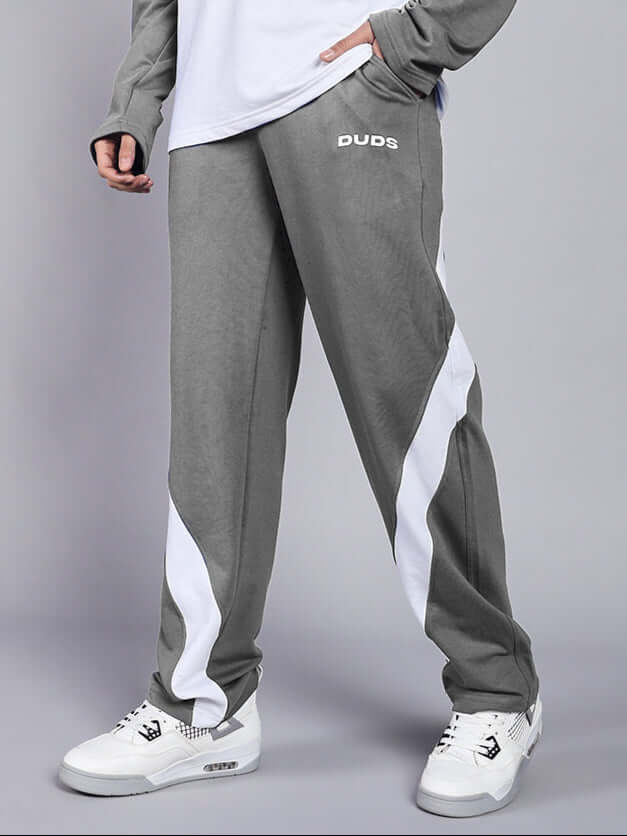 Person wearing grey and white Celestine relaxed fit jogger pants by DUDS, standing in casual pose, highlighting product design.