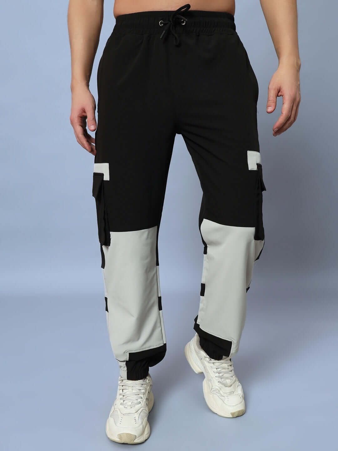 Chalet Relaxed Fit Cargo Pants in Black Grey with Custom Fit option, shown paired with white sneakers, highlighting unique color block design.