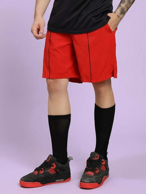 Man wearing CHAMPION ZONE FRONT PLATED SHORTS RED with black socks and shoes, showcasing athletic style and comfort.