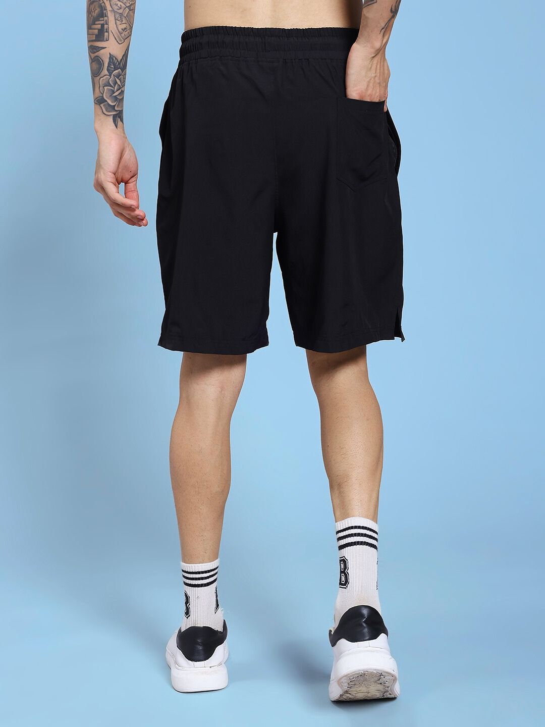 Man wearing CHAMPION ZONE FRONT PLATED SHORTS BLACK, showcasing back design, ideal for active and casual wear in breathable fabric.