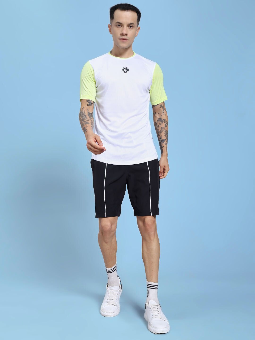 Man wearing CHAMPION ZONE REGULAR FIT CO-ORD SET WHITE NEON BLACK against blue background.