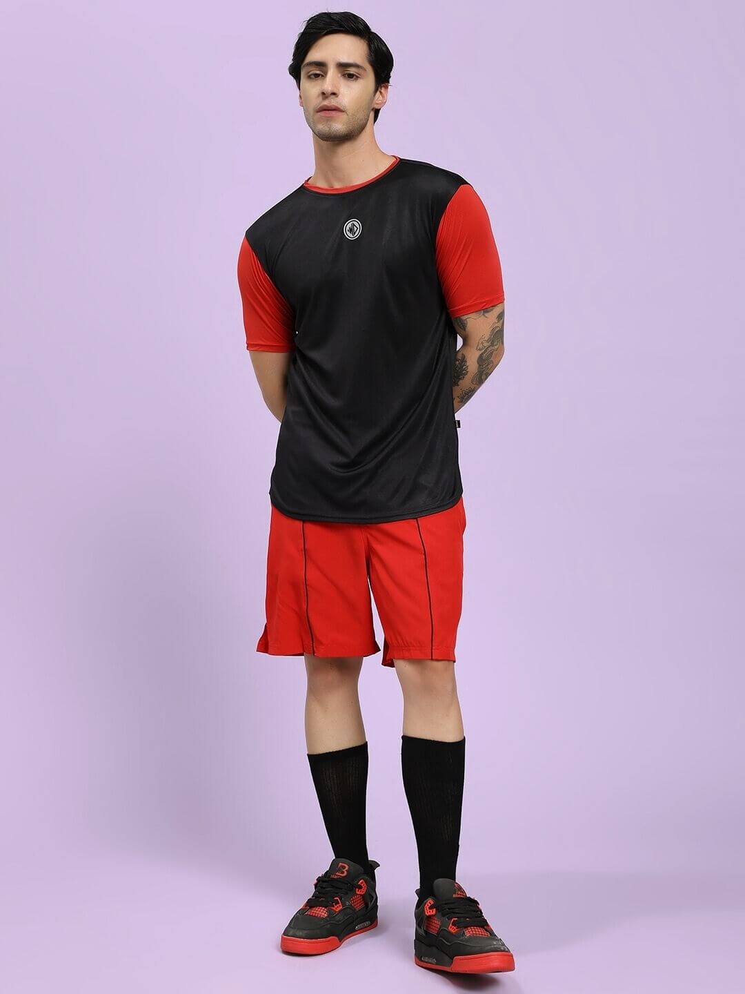 Male model wearing CHAMPION ZONE REGULAR FIT CO-ORD SET BLACK RED with black and red sports shoes, front view.