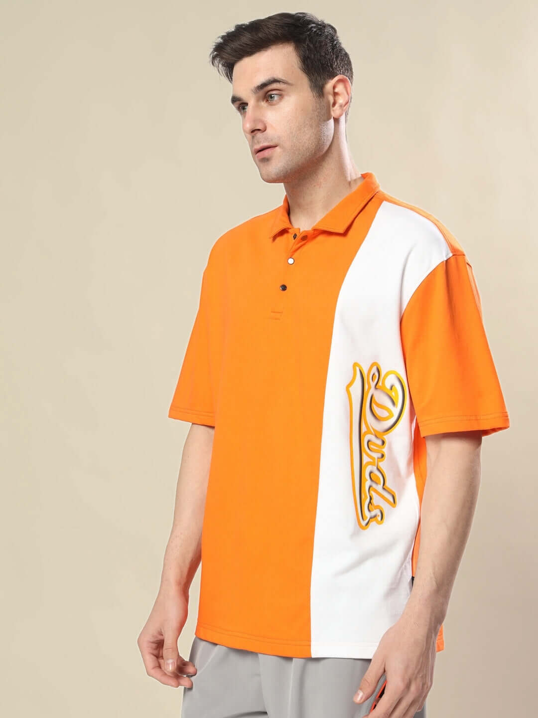 Fashionable male model wearing a cheugy oversized polo t-shirt in orange-white, made from premium cotton French terry, styled casually.