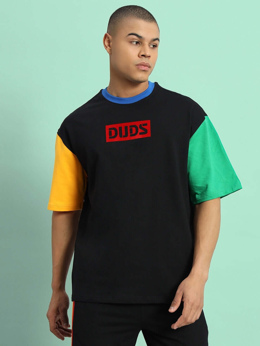 Chroma color blocked oversized black T-shirt with multicolor sleeves, worn by a model. Made from premium cotton for comfort and style.