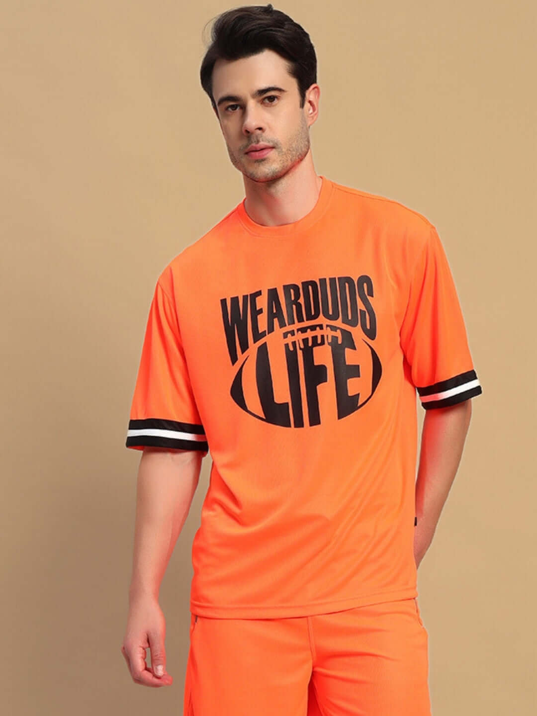 Man wearing oversized orange T-shirt labeled 'WEARDUDS FOR LIFE', offering Custom Fit option, perfect for casual style.