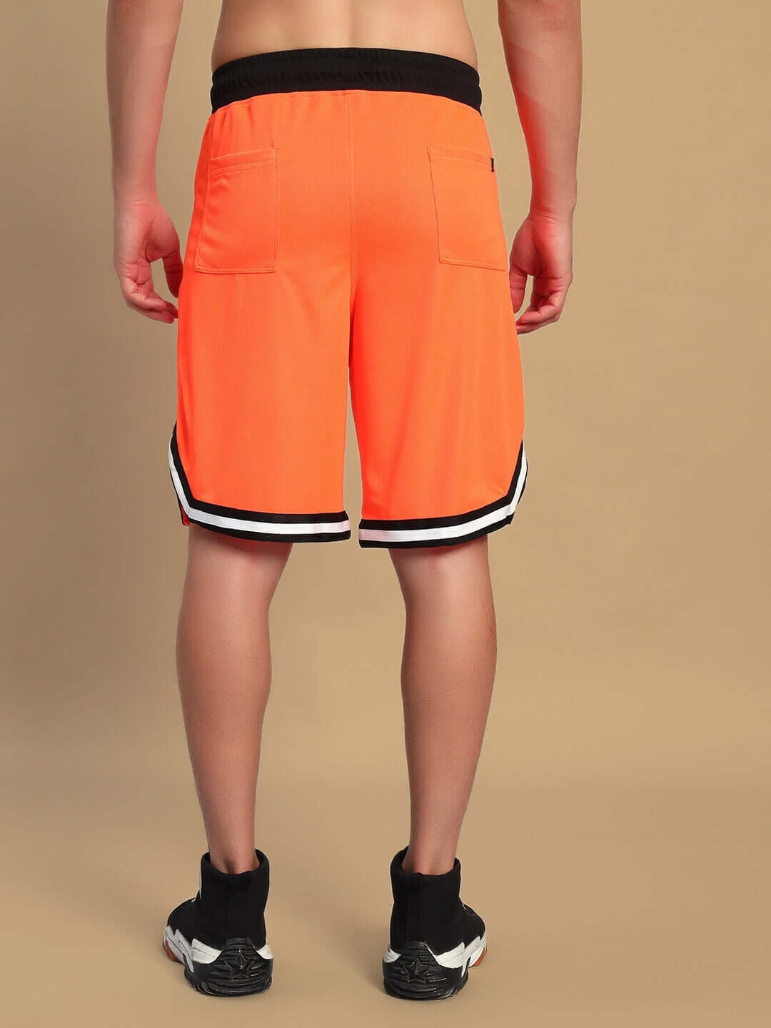 Person wearing orange CHRONIC regular fit shorts with black waistband, rear view.