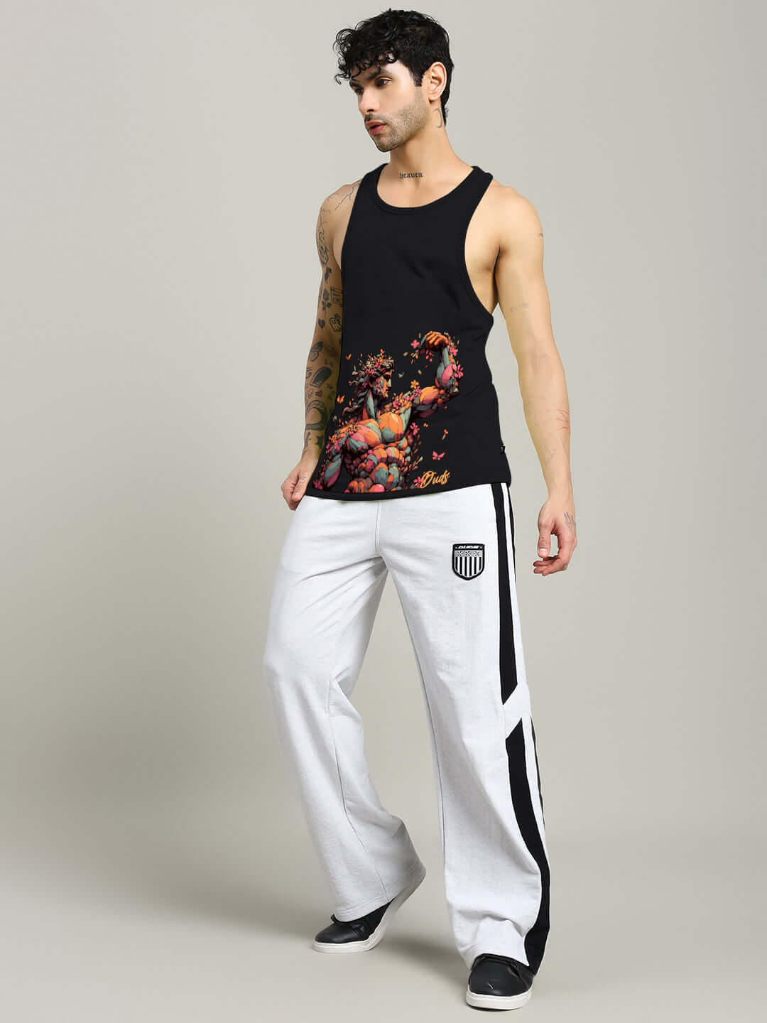 Man wearing a black Classical Greek gym t-shirt with printed design paired with white athletic pants.