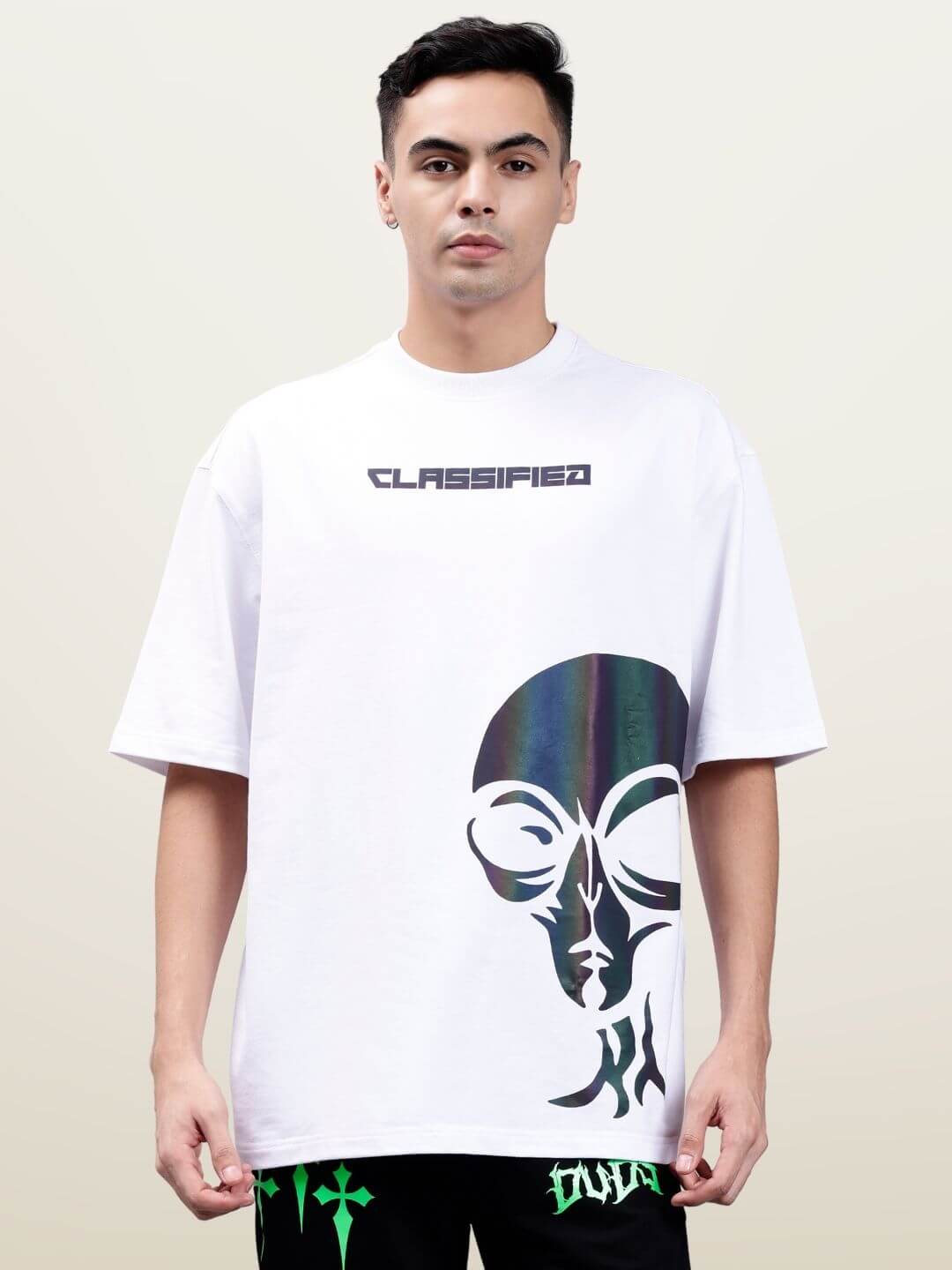 White oversized t-shirt with 'CLASSIFIED' text and artistic design, made from premium cotton French terry blend, worn by a model.