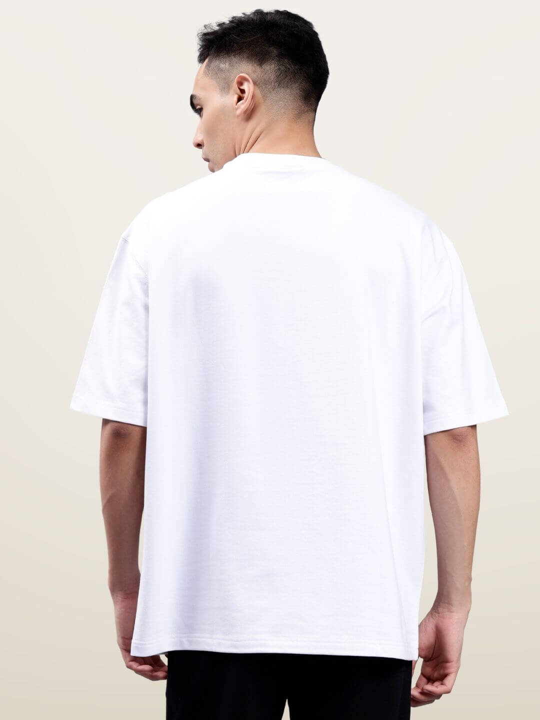 Back view of model wearing classified reflector oversized white t-shirt made from premium cotton blend, India-made fashion.