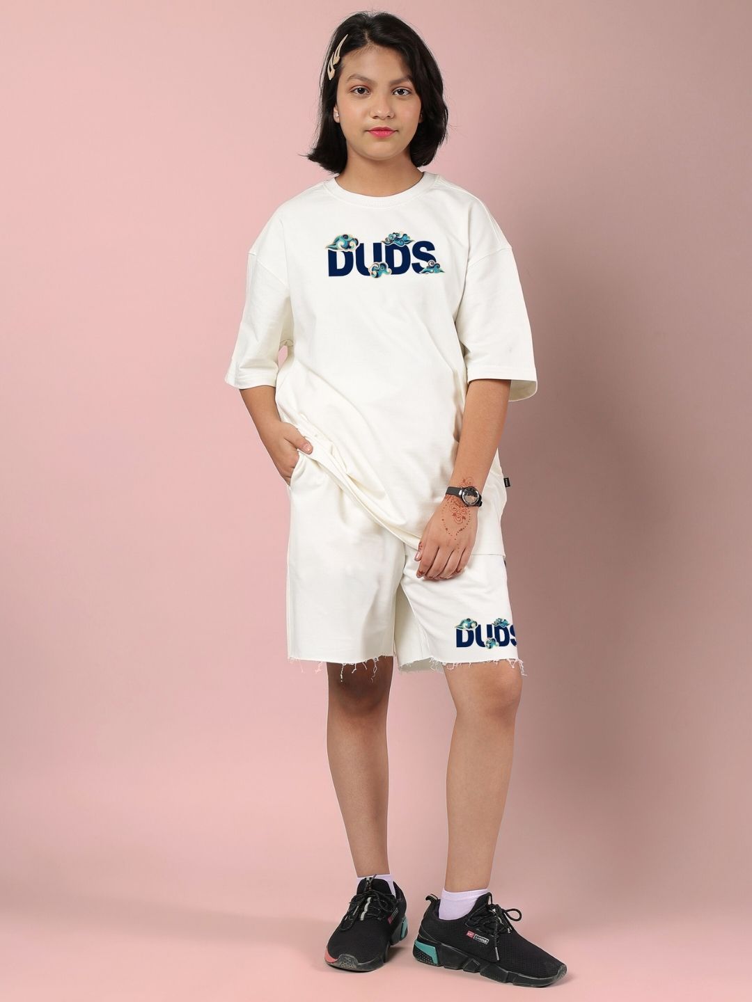 Child wearing CLOUD PRINTED CO-ORD FOR BOYS AND GIRLS OFF WHITE outfit, standing against pink background