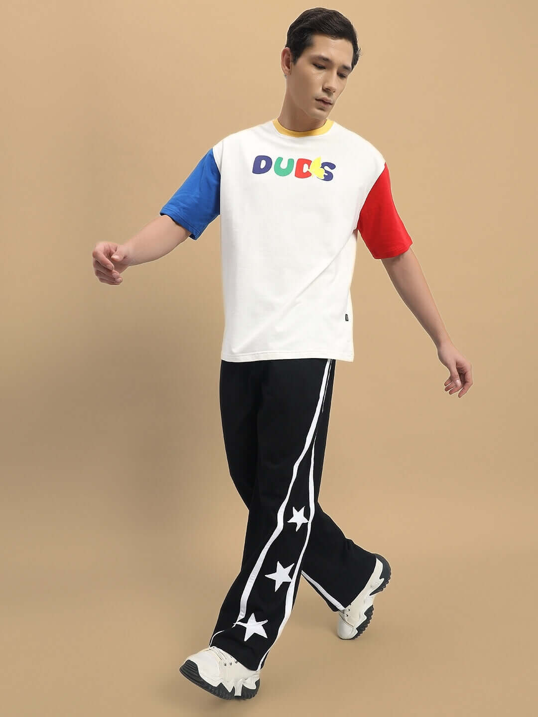 Model wearing DUDS Stellar Relaxed Joggers in black with star design, showcasing casual style and customization options.