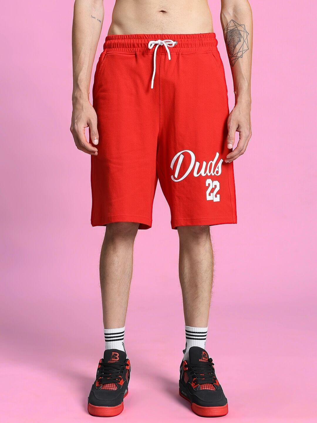 Model wearing Columbia 22 Print Summer Co-Ord Set Black Red with red shorts and black sneakers, trendy urban streetwear style.