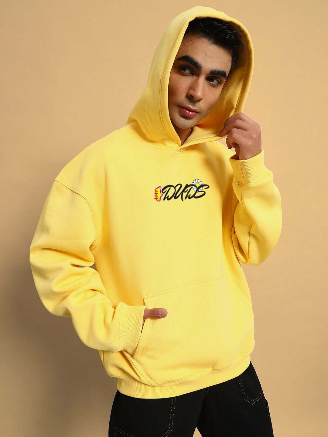 Model wearing CONFUSED FLEECE OVERSIZED HOODIE YELLOW with embroidered design, showcasing vibrant streetwear style and cozy comfort.
