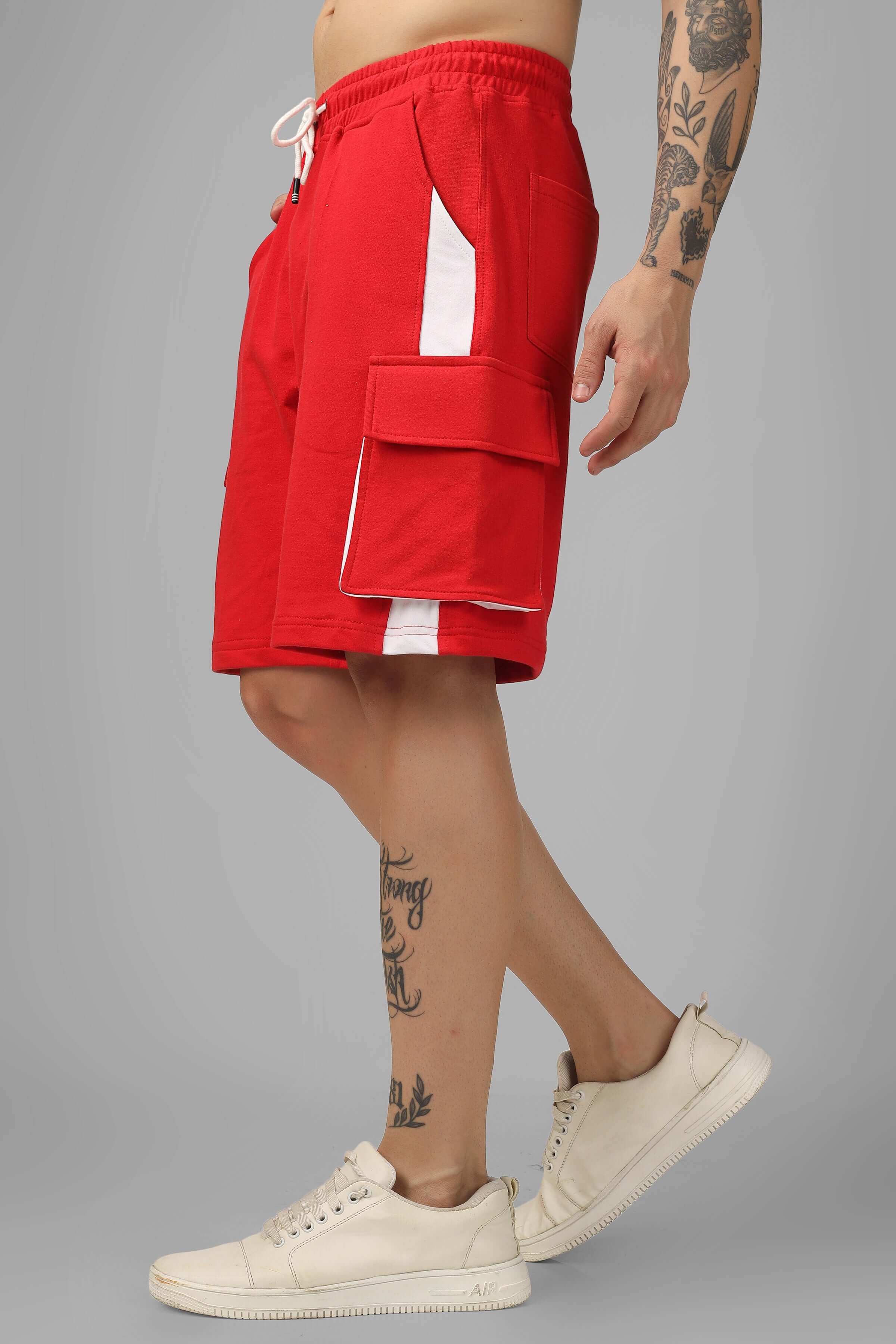 Side view of model wearing Contra Regular Fit Cargo Shorts in red and white, showcasing pocket details and sporty design.