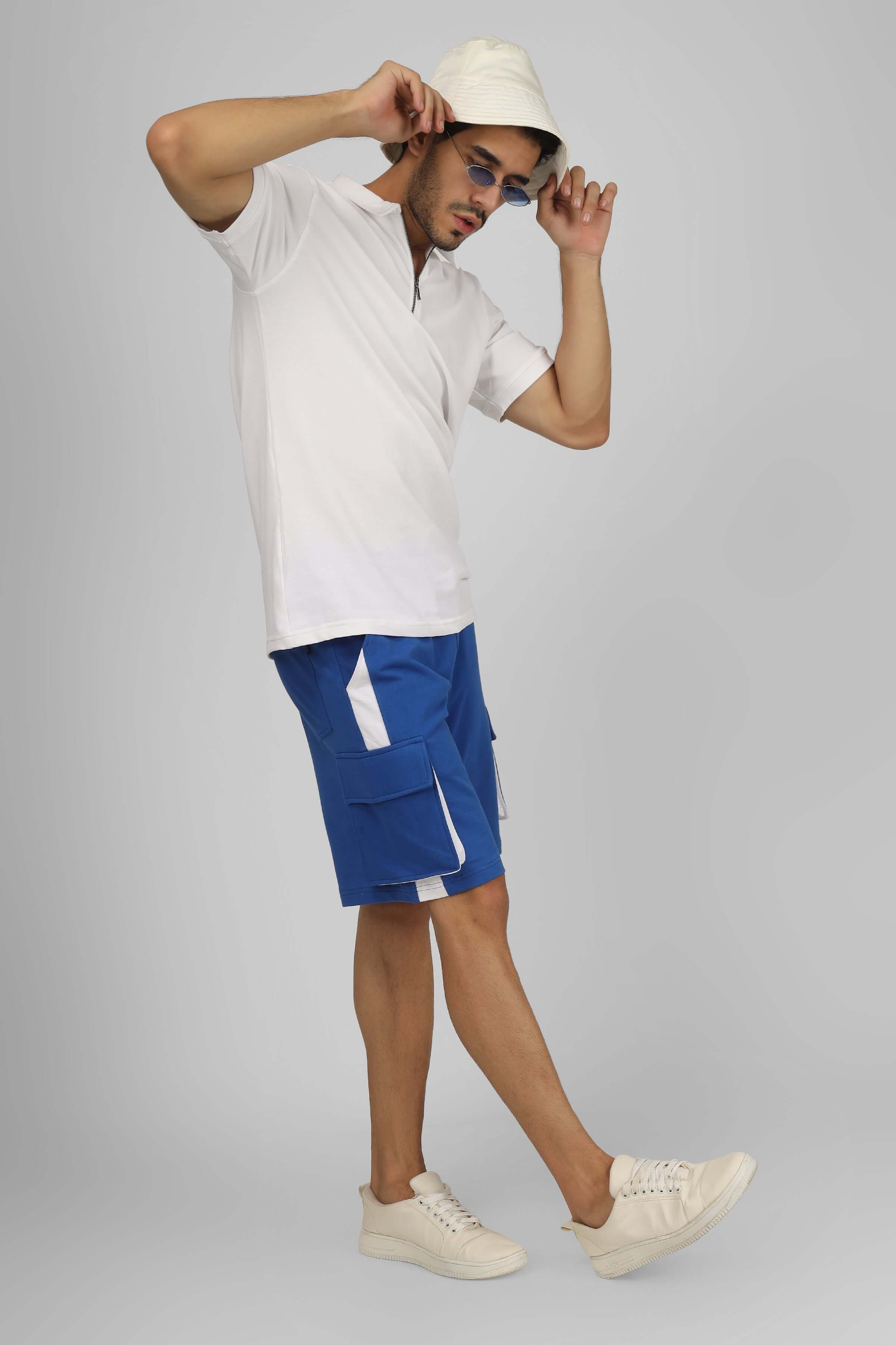 Model wearing Contra Regular Fit Cargo Shorts in Royal Blue & White with a white shirt and hat.