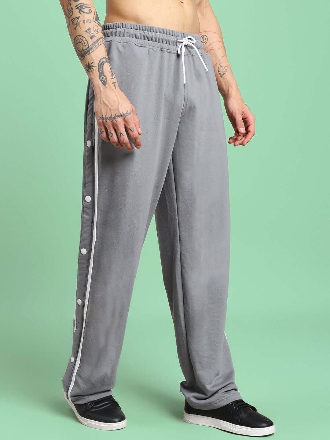 CONTRAST PANEL COTTON TERRY JOGGER GREY with button detailing on a model against a green background