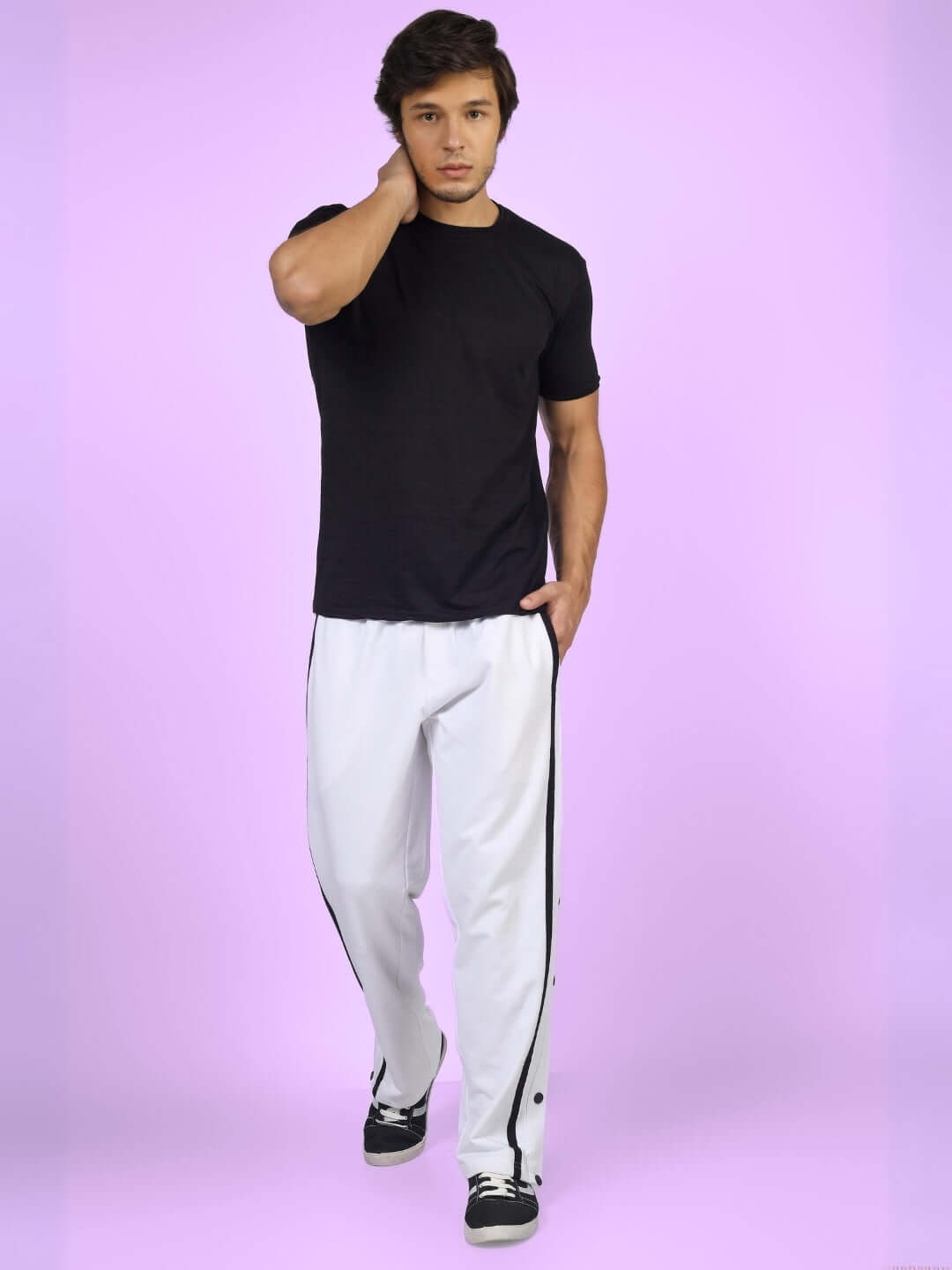 Model wearing white contrast panel joggers with black top against a purple background.