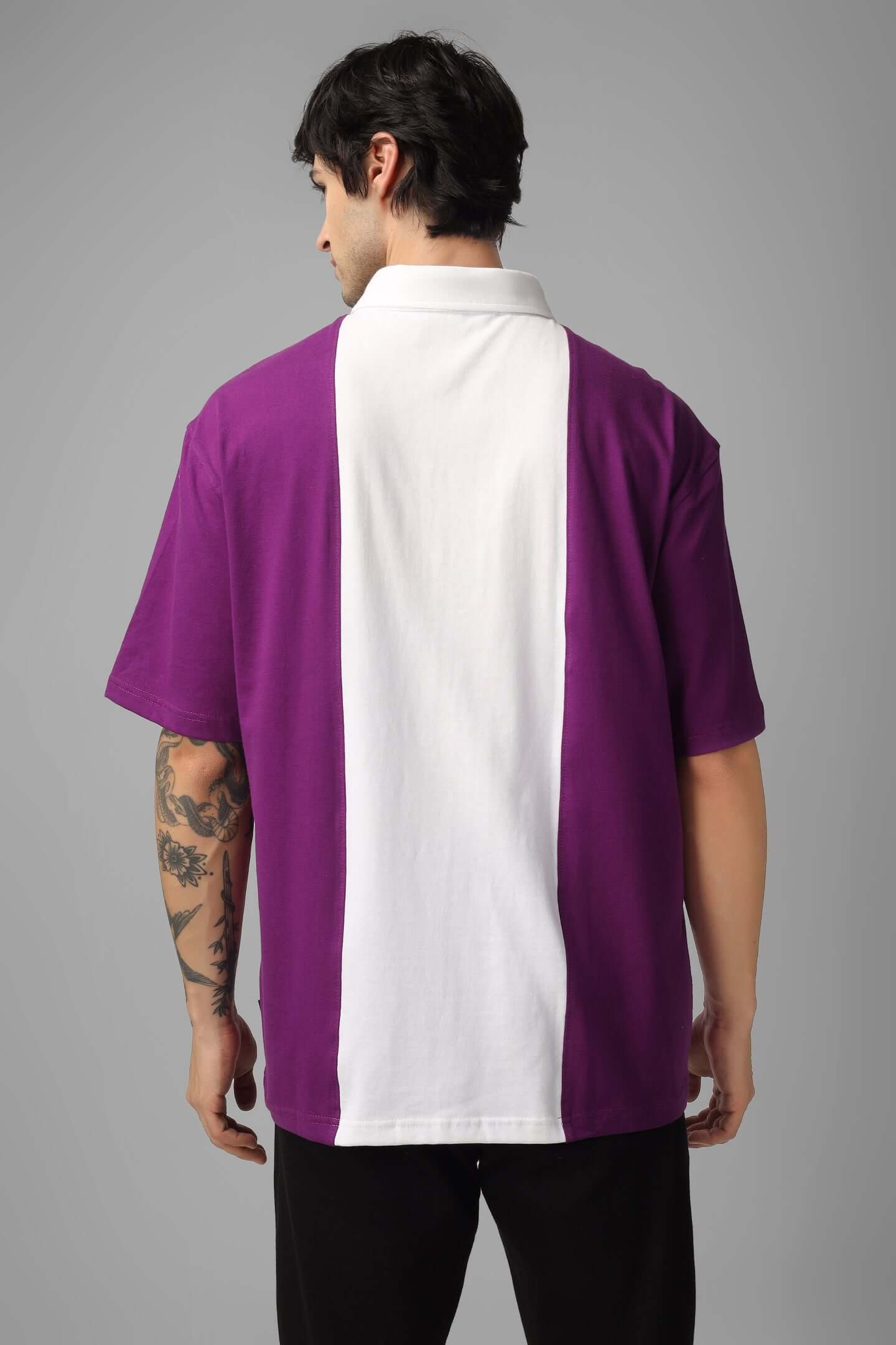 Model wearing a contrast purple-white oversized polo zipper t-shirt, back view, showcasing half sleeves and comfortable fit, made of 100% cotton.