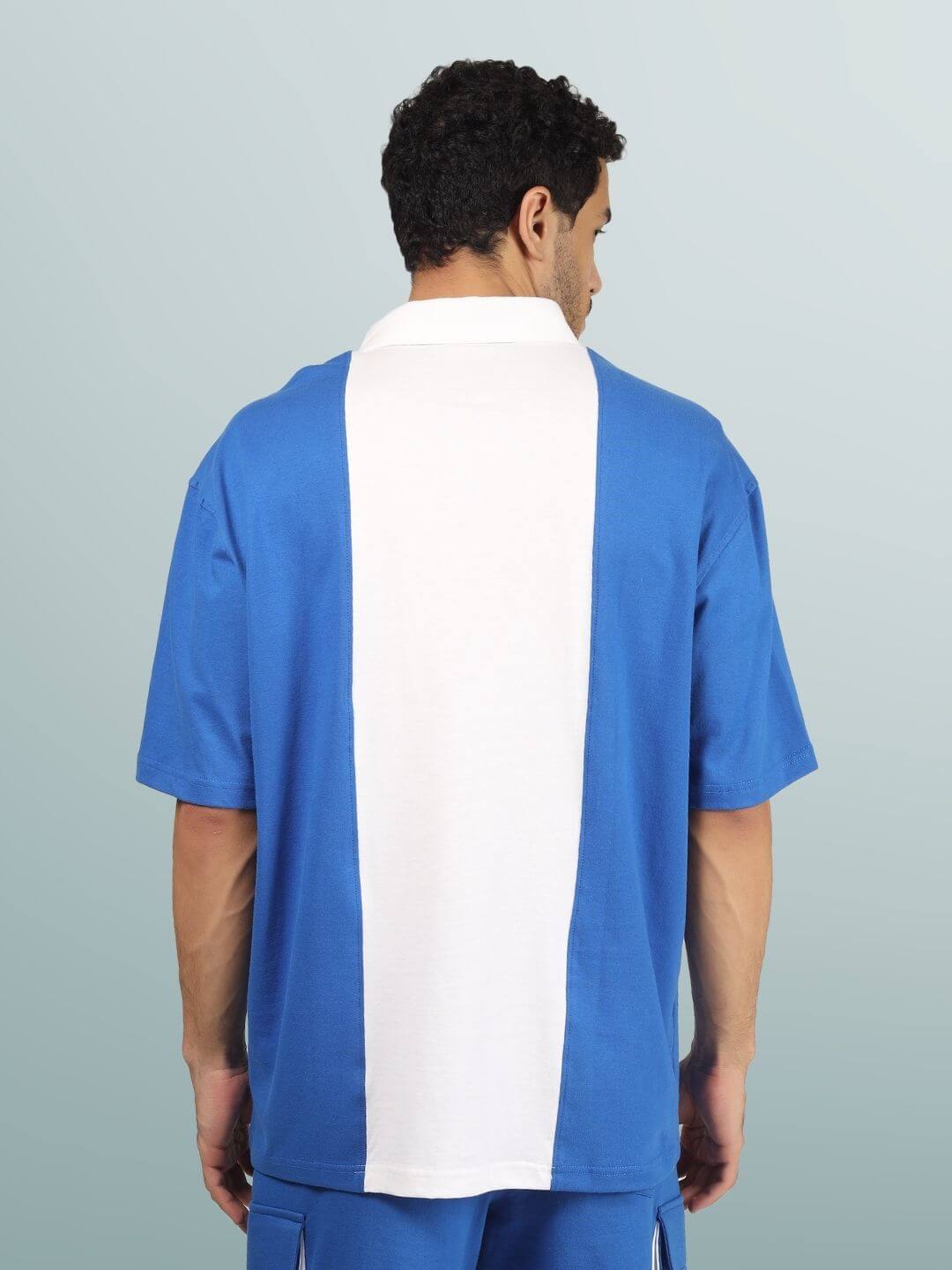 Model wearing blue-white contrast oversized polo t-shirt with metal zipper, showcasing the back view. Premium heavy gauge 100% cotton fabric.