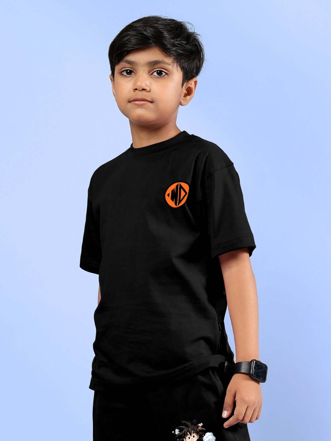 Boy wearing a black Goku printed t-shirt from DUDS, featuring an orange symbol, suitable for boys and girls, customizable fit option available