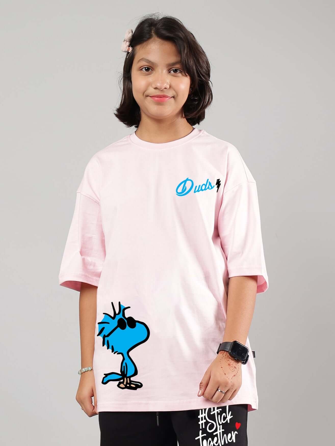 Child wearing COOL PALS pink oversized t-shirt with cartoon design, showcasing casual style for boys and girls by DUDS.