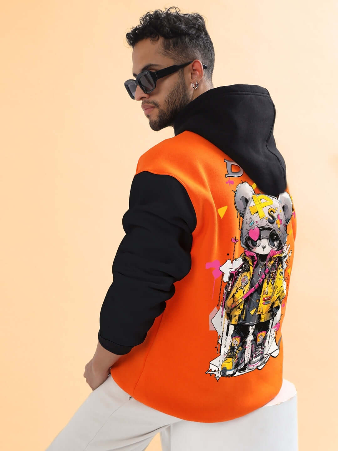 Model wearing COOL TEDDY FLEECE COLORBLOCK OVERSIZE HOODIE ORANGE BLACK with graphic back design, showcasing bold street style.