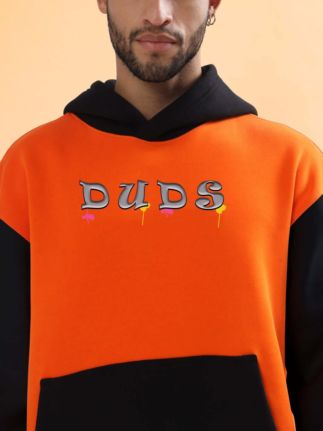Man wearing COOL TEDDY FLEECE COLORBLOCK OVERSIZE HOODIE ORANGE BLACK with bold lettering and colorblock design.