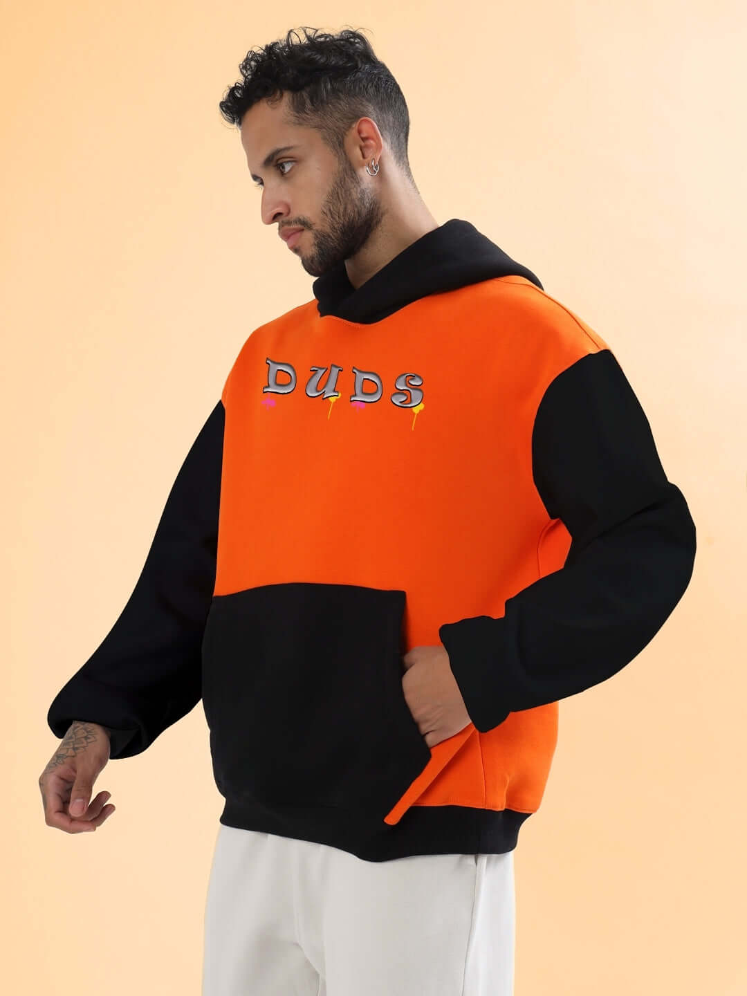 Man wearing COOL TEDDY FLEECE COLORBLOCK OVERSIZE HOODIE ORANGE BLACK with vibrant colorblock design, blending warmth and street style.