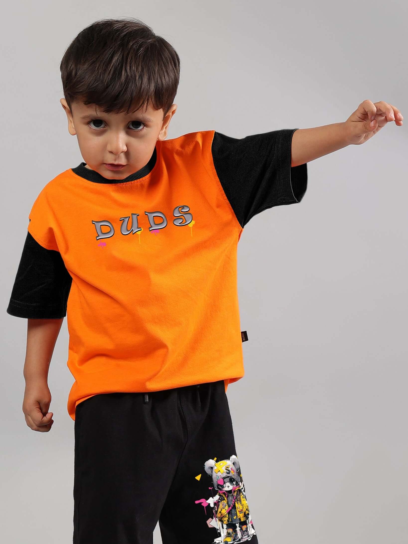 Boy wearing orange DUDS teddy t-shirt, made-to-order clothing for boys and girls, customizable fit available.