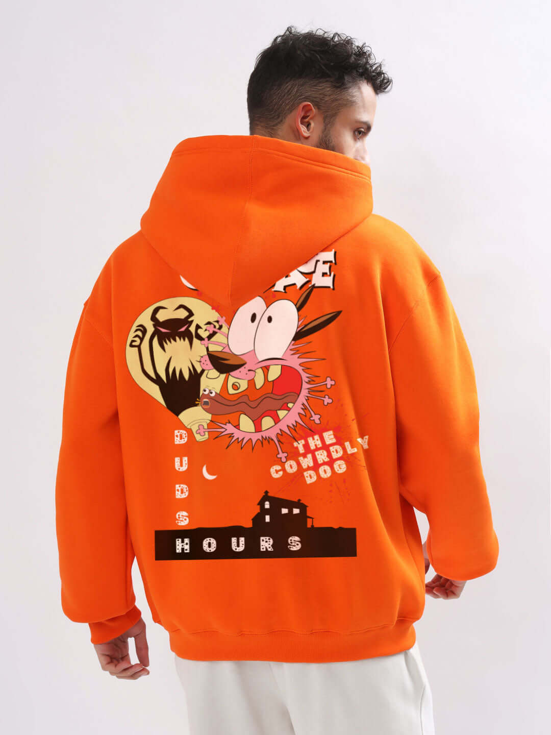 Person wearing an orange oversized hoodie with cartoon graphic on the back and text 'COURAGE' and 'THE COWARDLY DOG'.