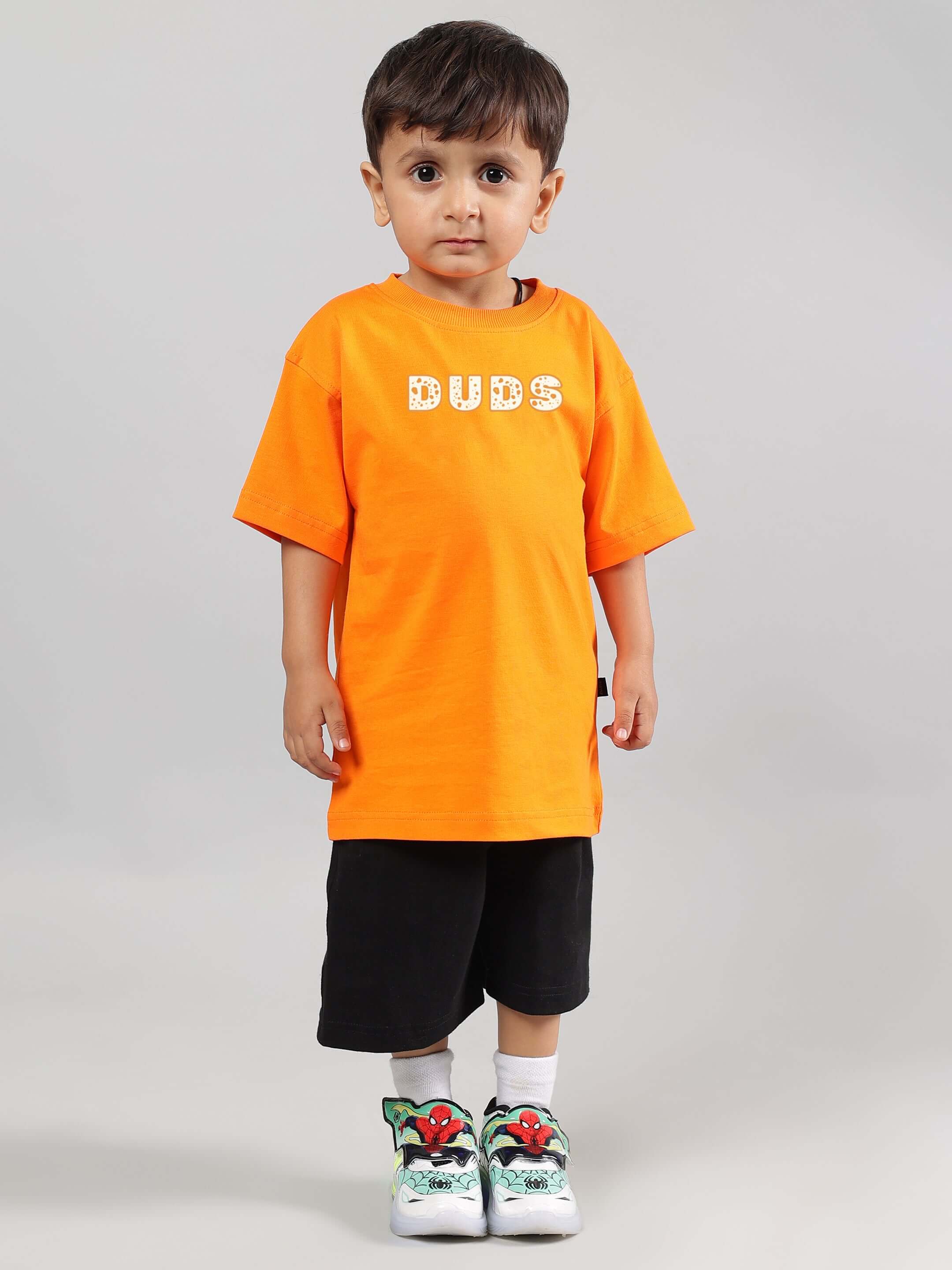 Child wearing COURAGE TOON CO-ORD FOR BOYS GIRLS ORANGE-BLACK, featuring bold orange t-shirt and black shorts, perfect unisex playwear.