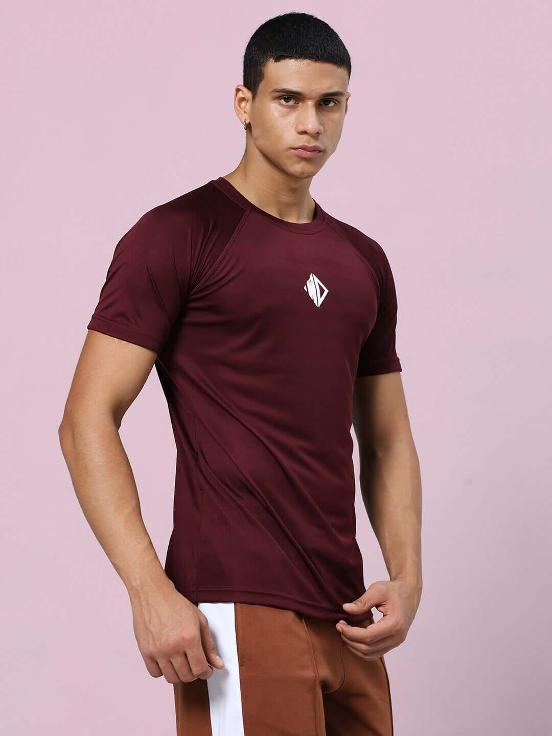 Man wearing CRISTINIO Maroon Regular Fit T-Shirt, crafted from sports polyester fabric. Ideal for a stylish and comfortable look.