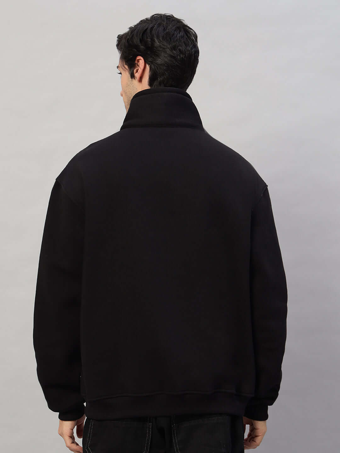 Back view of a person wearing a black Crossbar Fleece Colorblock Jacket, highlighting its design and fit.